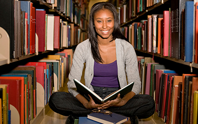 Female in Library Reading Book