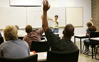 Student Raising Their Hand In The Classroom